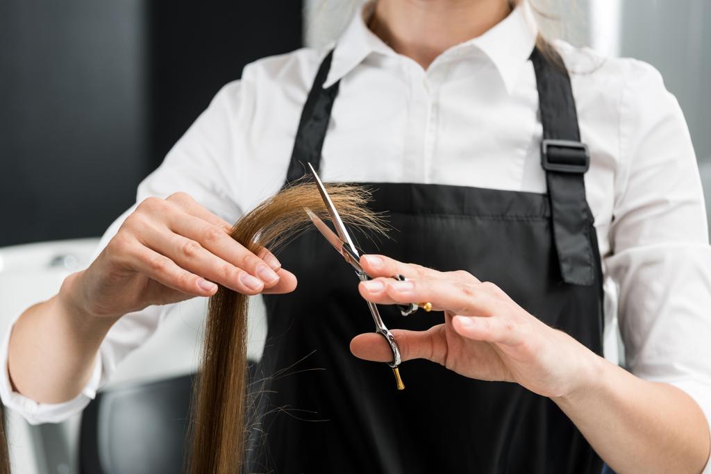 Woman getting a hair cut trimming off split ends